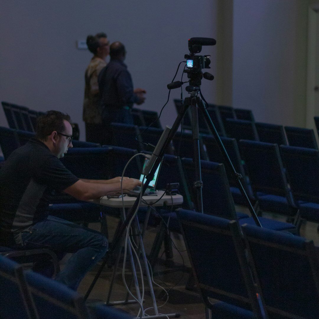 Camera operator filming a live news anchor in a television studio