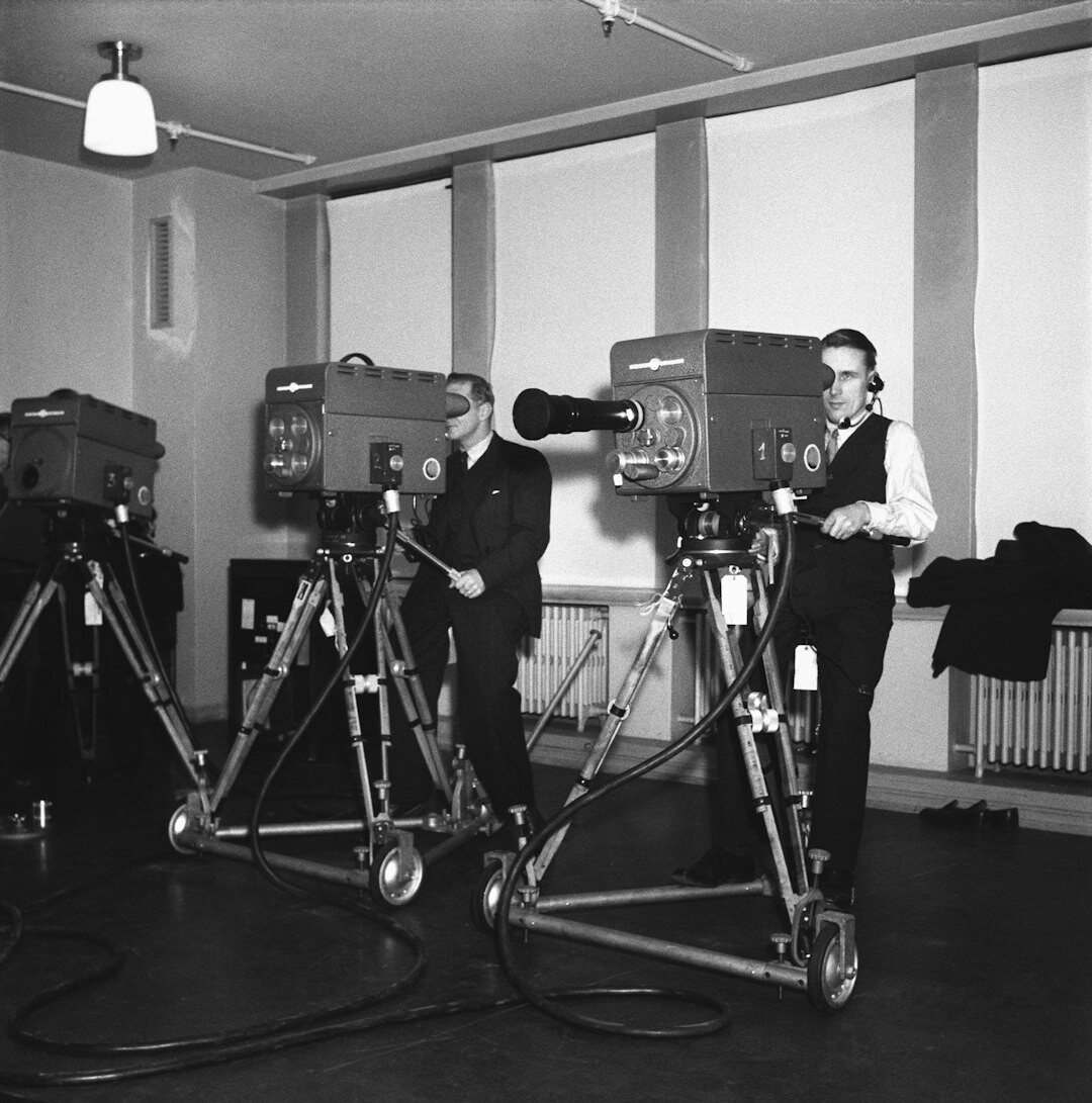 Two production specialists reviewing broadcast footage on a monitor together