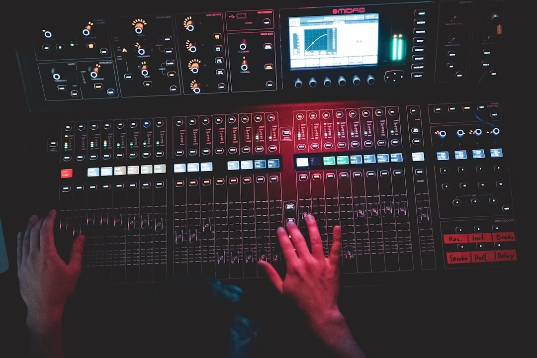 Close-up of hands operating a video vision mixer switcher panel with glowing buttons